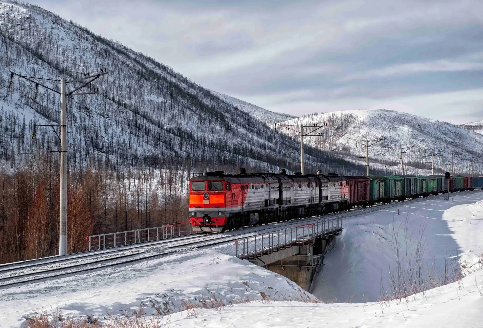 Freight train hauling coal wagons through snowy Russian Far Eastern landscape