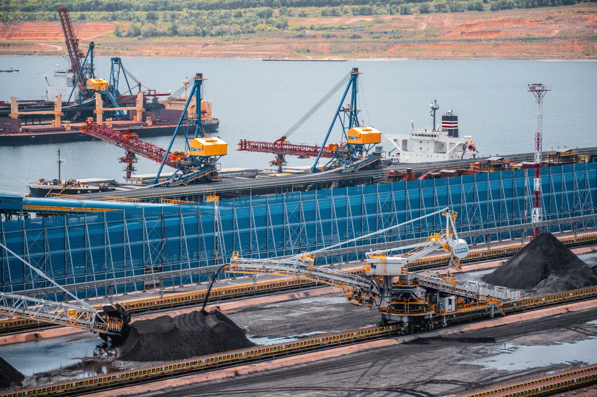 Coal export terminal with conveyors, stockpiles, and bulk carriers in the global seaborne coal market