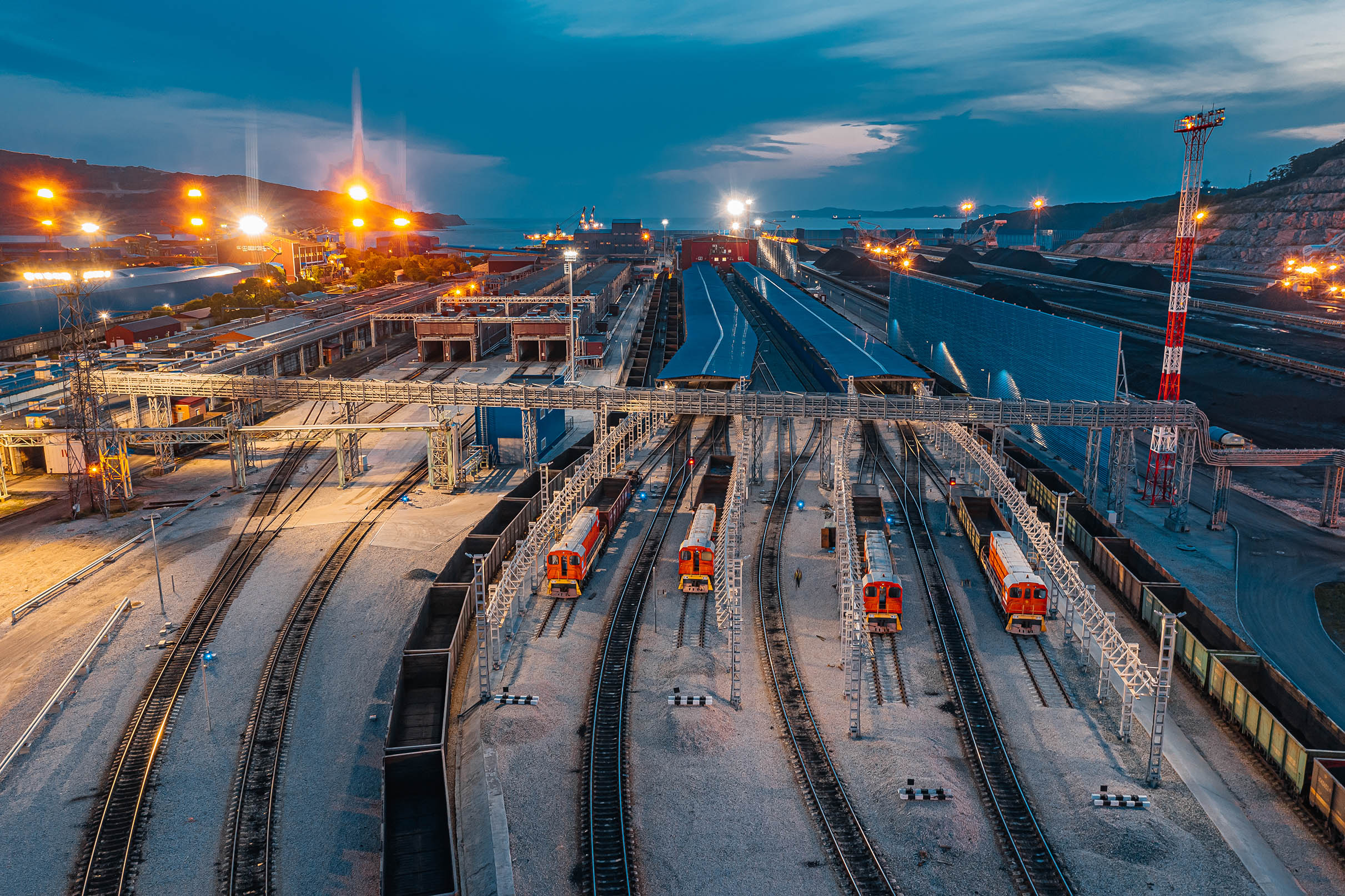 Coal export terminal with rail infrastructure and stockpiles at dusk