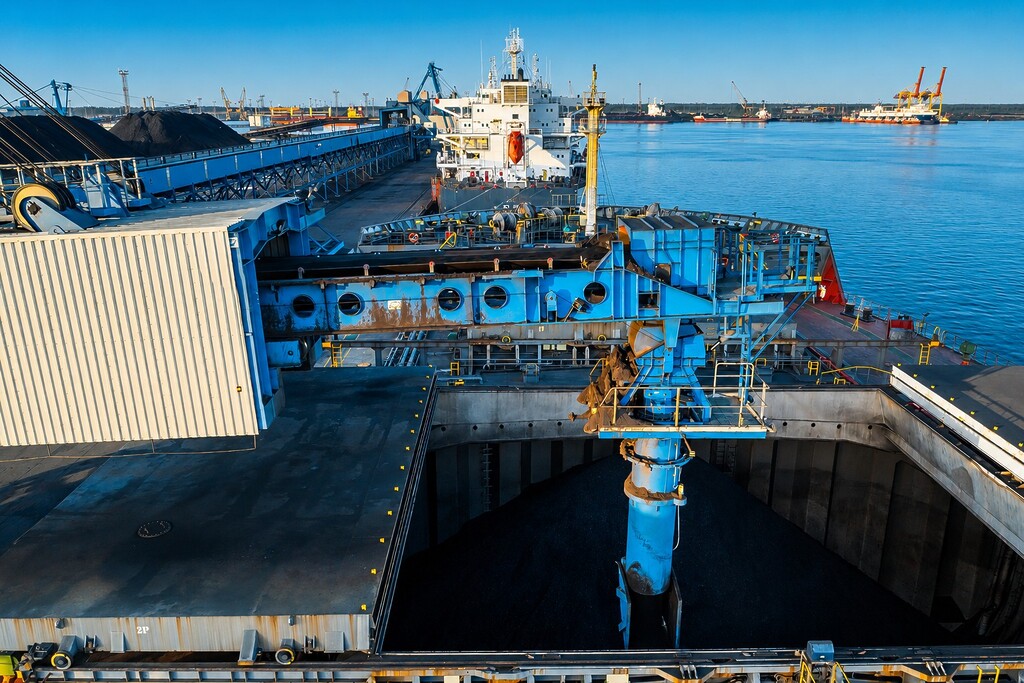 Coal being loaded onto a bulk carrier at an industrial port terminal