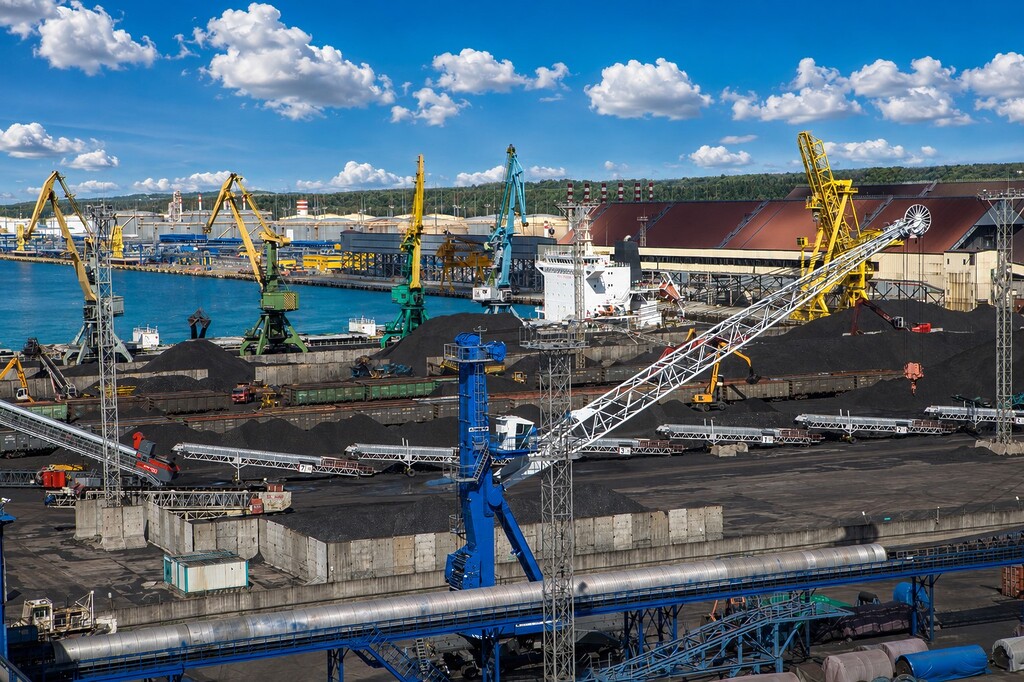 Coal export terminal with stockpiles, conveyors, cranes and a cargo vessel