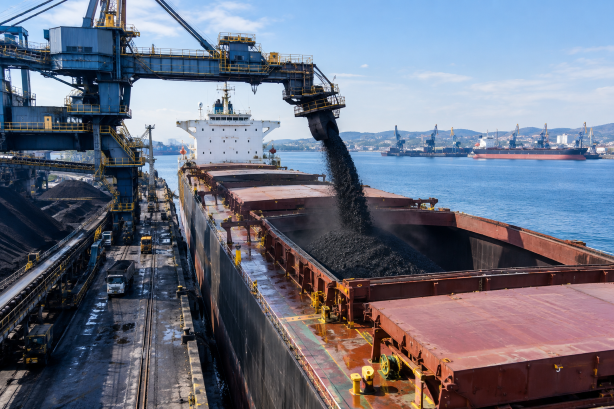 Coal being loaded from terminal equipment into a bulk carrier at an export port.