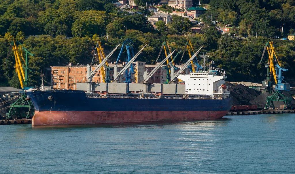 Bulk carrier being loaded with coal at a port near an urban area in the Russian Far East.