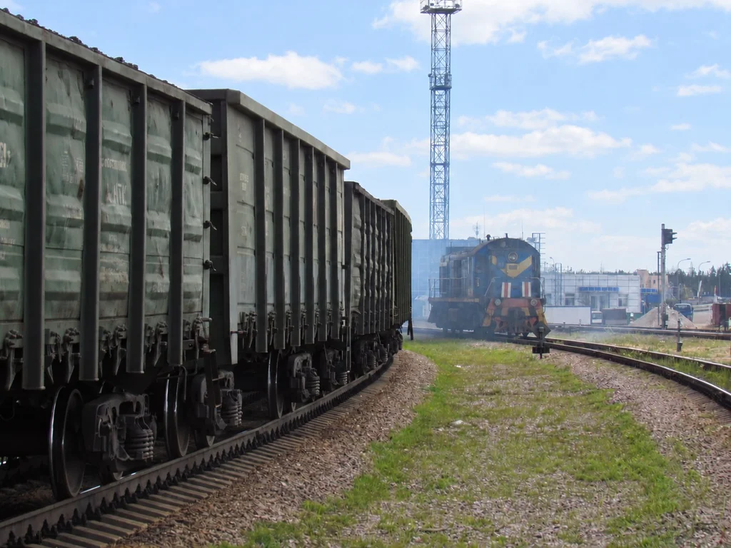 Coal freight wagons on railway tracks with a locomotive at a rail terminal.